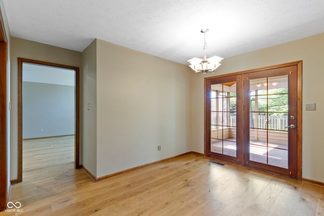 5037 Surrey Ln, Carmel, IN 46033 - unfurnished room featuring a chandelier, light wood finished floors, and a textured ceiling