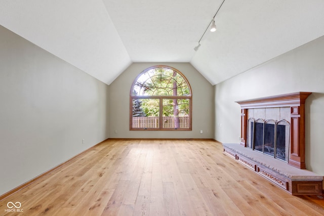 5037 Surrey Ln, Carmel, IN 46033 - unfurnished living room featuring rail lighting, hardwood / wood-style flooring, vaulted ceiling, and a fireplace