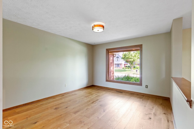 5037 Surrey Ln, Carmel, IN 46033 - unfurnished room with light wood-style floors and a textured ceiling