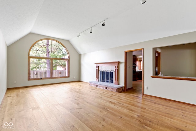 5037 Surrey Ln, Carmel, IN 46033 - unfurnished living room featuring track lighting, lofted ceiling, wood finished floors, and a fireplace with raised hearth