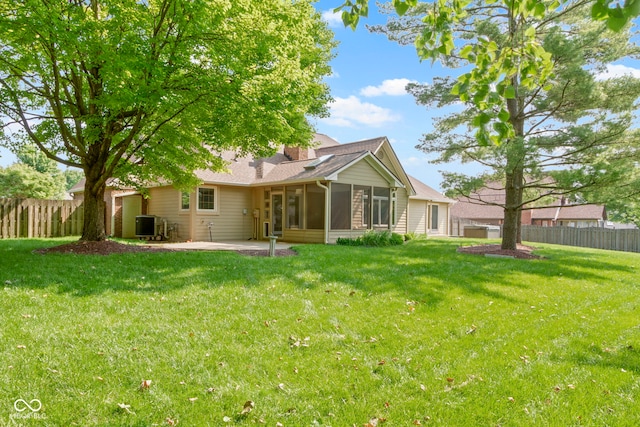 5037 Surrey Ln, Carmel, IN 46033 - back of house featuring a sunroom, a patio area, a chimney, and a shingled roof