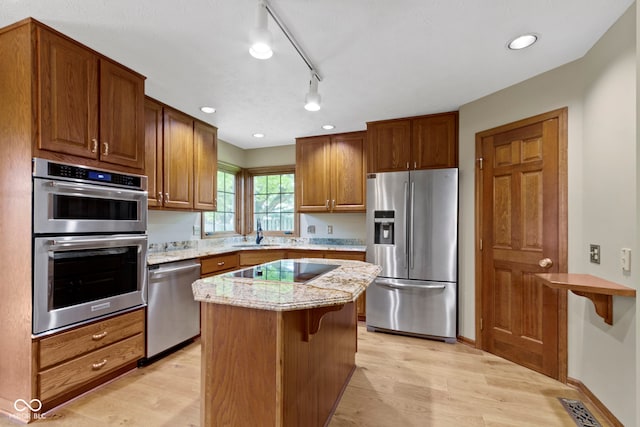 5037 Surrey Ln, Carmel, IN 46033 - kitchen with stainless steel appliances, light wood-style flooring, a kitchen island, light stone counters, and recessed lighting