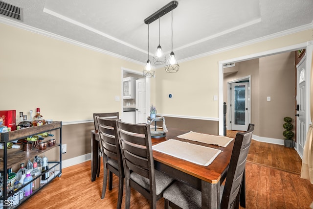7833 Meadow Bend Dr, Indianapolis, IN 46259 - dining area featuring a tray ceiling, light wood-type flooring, ornamental molding, and baseboards