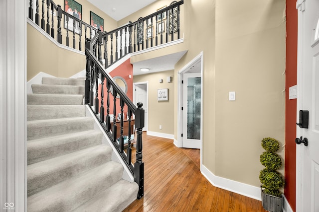 7833 Meadow Bend Dr, Indianapolis, IN 46259 - foyer featuring baseboards, wood-type flooring, stairway, and a towering ceiling