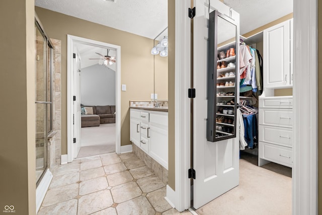 7833 Meadow Bend Dr, Indianapolis, IN 46259 - bathroom featuring vanity, ceiling fan, a walk in closet, a stall shower, and a textured ceiling