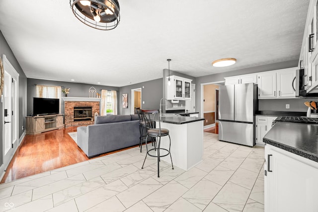 7833 Meadow Bend Dr, Indianapolis, IN 46259 - kitchen with appliances with stainless steel finishes, light marble finish floors, dark countertops, and a breakfast bar