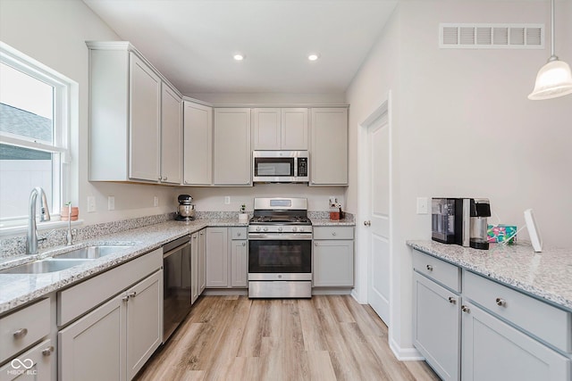 3643 Thomas Jefferson St, Westfield, IN 46074 - kitchen featuring stainless steel appliances, light wood-style floors, light stone countertops, gray cabinetry, and recessed lighting