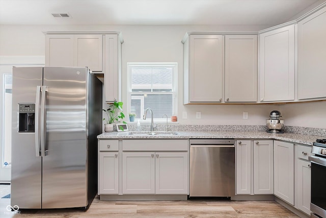 3643 Thomas Jefferson St, Westfield, IN 46074 - kitchen featuring appliances with stainless steel finishes, light stone counters, and light wood-style floors
