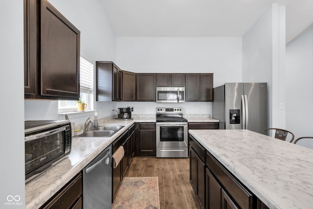 12105 Fall Ct, Indianapolis, IN 46229 - kitchen featuring appliances with stainless steel finishes, dark brown cabinetry, wood finished floors, and light countertops