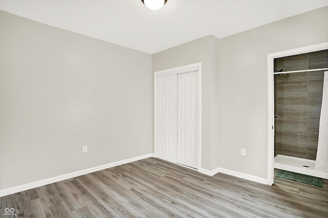 1338 N Parker Ave, Indianapolis, IN 46201 - unfurnished bedroom with wood finished floors, baseboards, and a closet