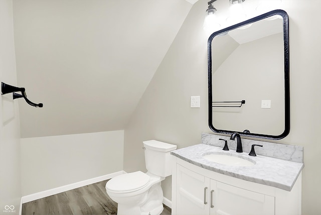 1338 N Parker Ave, Indianapolis, IN 46201 - half bathroom featuring toilet, vanity, vaulted ceiling, wood finished floors, and baseboards