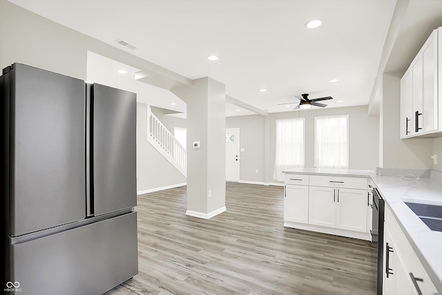 1338 N Parker Ave, Indianapolis, IN 46201 - kitchen with freestanding refrigerator, a peninsula, white cabinets, a ceiling fan, and light wood-style floors