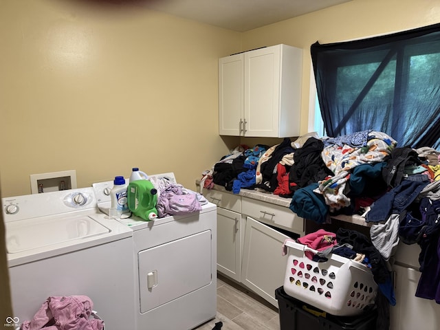 laundry room with separate washer and dryer, cabinet space, and light wood-style flooring