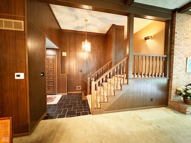 7038 E 65th St, Indianapolis, IN 46256 - staircase featuring wooden walls, vaulted ceiling, and carpet floors