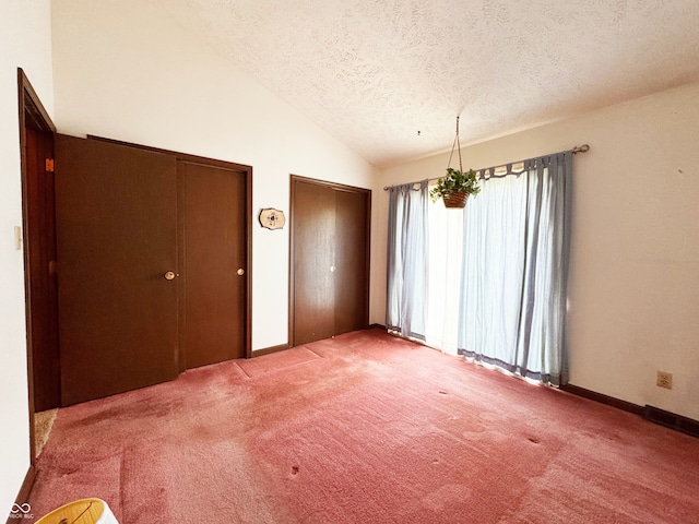 7038 E 65th St, Indianapolis, IN 46256 - unfurnished dining area featuring a textured ceiling, lofted ceiling, and carpet floors