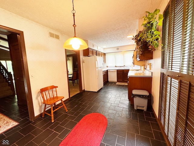 7038 E 65th St, Indianapolis, IN 46256 - kitchen with white appliances, a textured ceiling, light countertops, plenty of natural light, and pendant lighting