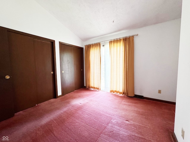 7038 E 65th St, Indianapolis, IN 46256 - unfurnished bedroom featuring two closets, lofted ceiling, and carpet