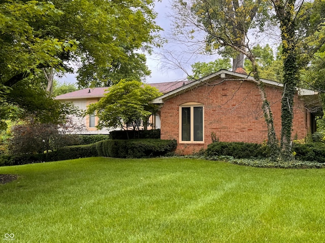 7038 E 65th St, Indianapolis, IN 46256 - view of property exterior featuring brick siding, a lawn, and a chimney