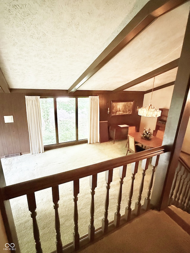 7038 E 65th St, Indianapolis, IN 46256 - stairs with carpet, beamed ceiling, a textured ceiling, and wooden walls