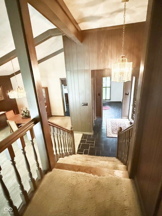 7038 E 65th St, Indianapolis, IN 46256 - hall featuring a chandelier, wood walls, and stone finish flooring