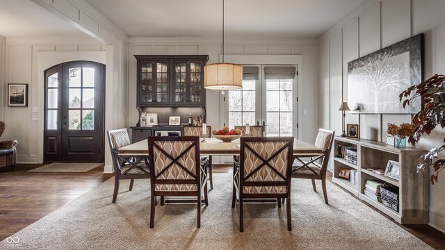 10974 Harbor Bay Dr, Fishers, IN 46040 - dining room featuring wood finished floors, a decorative wall, and ornamental molding
