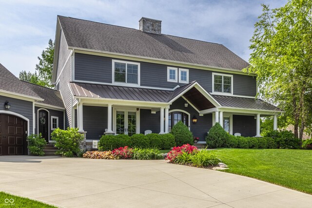 10974 Harbor Bay Dr, Fishers, IN 46040 - view of front of property with covered porch, a front lawn, a metal roof, and a chimney
