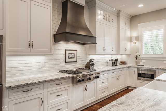 10974 Harbor Bay Dr, Fishers, IN 46040 - kitchen featuring premium range hood, stainless steel gas stovetop, white cabinets, dark wood-style flooring, and backsplash