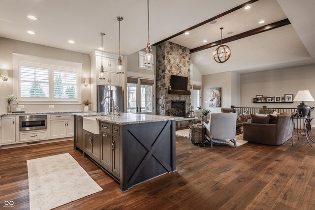 10974 Harbor Bay Dr, Fishers, IN 46040 - kitchen with open floor plan, white cabinets, a fireplace, dark wood-style flooring, and light stone counters