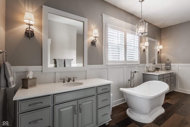 10974 Harbor Bay Dr, Fishers, IN 46040 - full bath with wainscoting, a freestanding tub, vanity, a decorative wall, and wood finished floors