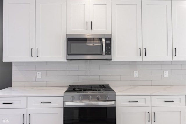 2051-2053 Columbia Ave, Indianapolis, IN 46202 - kitchen featuring stainless steel appliances, white cabinetry, backsplash, and light stone counters