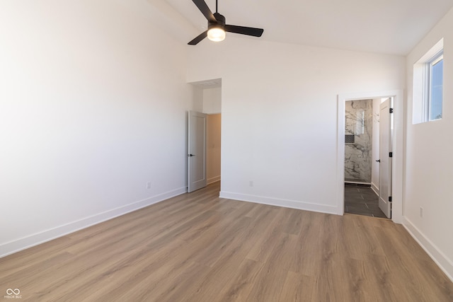 2051-2053 Columbia Ave, Indianapolis, IN 46202 - unfurnished bedroom with light wood finished floors, baseboards, high vaulted ceiling, ensuite bathroom, and a ceiling fan