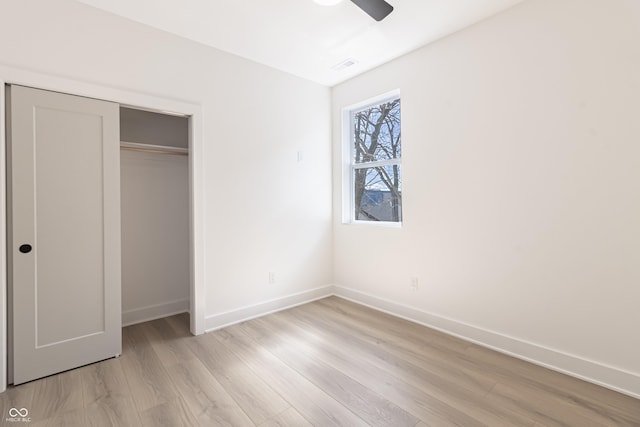 2051-2053 Columbia Ave, Indianapolis, IN 46202 - unfurnished bedroom with light wood-style flooring, baseboards, a closet, and ceiling fan
