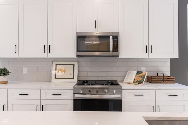 2051-2053 Columbia Ave, Indianapolis, IN 46202 - kitchen with stainless steel appliances, white cabinetry, tasteful backsplash, and light stone counters