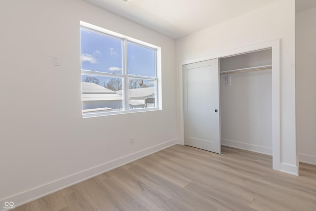 2051-2053 Columbia Ave, Indianapolis, IN 46202 - unfurnished bedroom with light wood finished floors, baseboards, and a closet