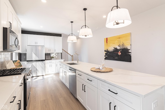 2051-2053 Columbia Ave, Indianapolis, IN 46202 - kitchen with appliances with stainless steel finishes, a sink, tasteful backsplash, light wood-style flooring, and recessed lighting