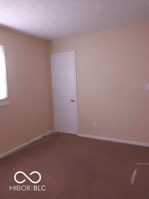 2250 N Goodlet Ave, Indianapolis, IN 46222 - carpeted spare room with a textured ceiling and baseboards