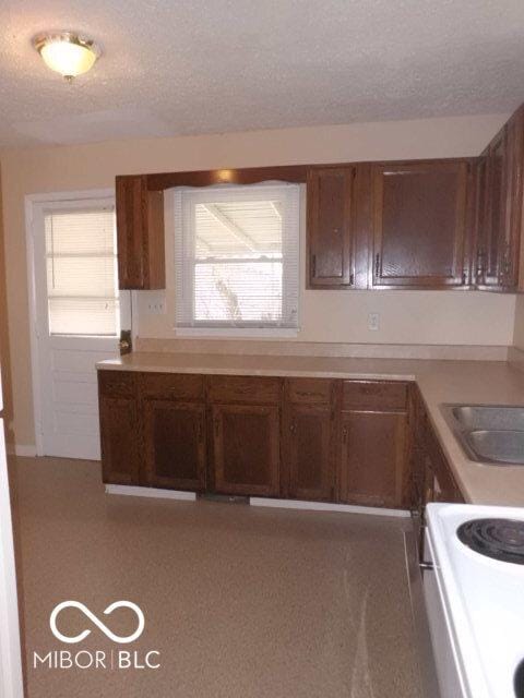 2250 N Goodlet Ave, Indianapolis, IN 46222 - kitchen with electric range, light countertops, and a textured ceiling