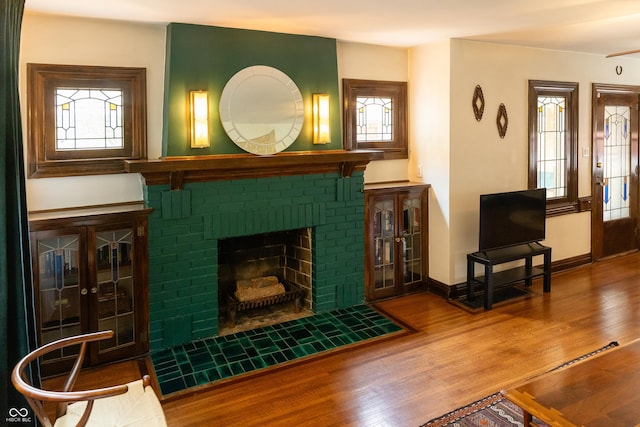 972 N Audubon Rd, Indianapolis, IN 46219 - living area featuring wood finished floors, healthy amount of natural light, and a fireplace