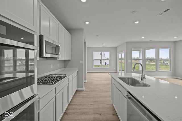 12500 Morning Ridge Way, Noblesville, IN 46060 - kitchen with appliances with stainless steel finishes, a sink, light wood-style floors, recessed lighting, and baseboards