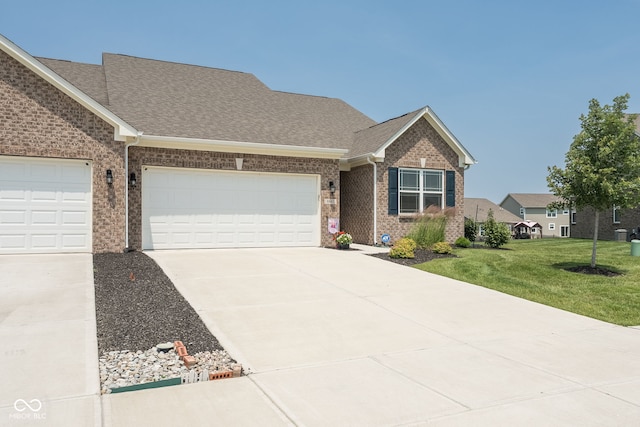 8842 Twain Ln, Indianapolis, IN 46239 - view of front facade with driveway, a front yard, brick siding, and a shingled roof