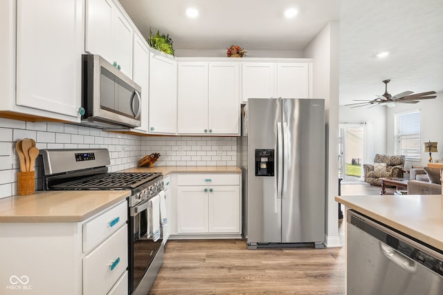 8842 Twain Ln, Indianapolis, IN 46239 - kitchen with appliances with stainless steel finishes, light countertops, light wood-style floors, white cabinetry, and recessed lighting