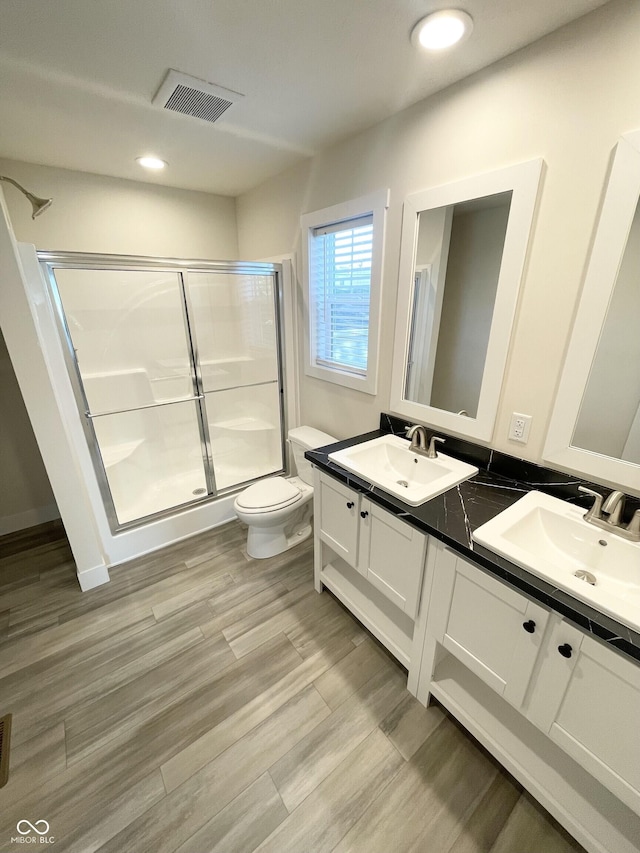 1628 Spann Ave, Indianapolis, IN 46203 - full bathroom featuring double vanity, a stall shower, wood finished floors, and recessed lighting