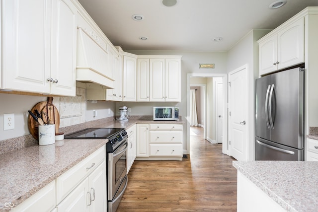 47 Torrey Pine Dr, Brownsburg, IN 46112 - kitchen with appliances with stainless steel finishes, light wood finished floors, white cabinets, recessed lighting, and custom range hood