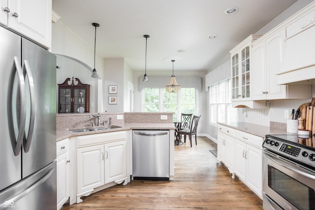 47 Torrey Pine Dr, Brownsburg, IN 46112 - kitchen featuring appliances with stainless steel finishes, light wood finished floors, glass insert cabinets, white cabinets, and a peninsula