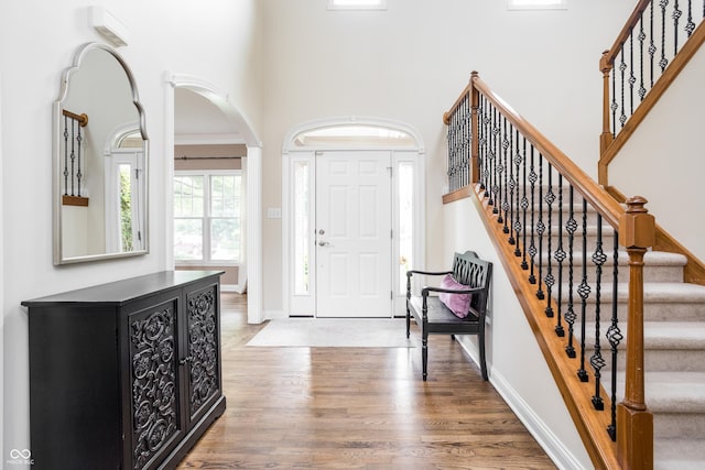 47 Torrey Pine Dr, Brownsburg, IN 46112 - entryway featuring wood finished floors, a high ceiling, arched walkways, and stairway