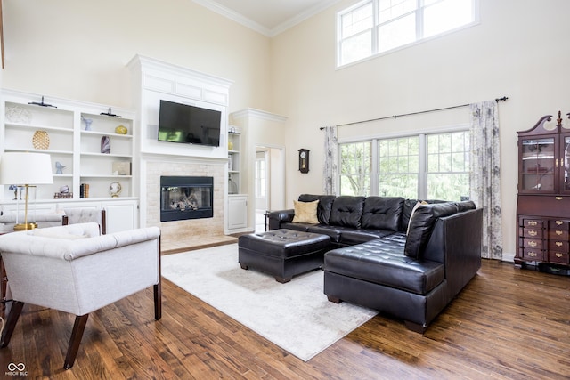 47 Torrey Pine Dr, Brownsburg, IN 46112 - living room featuring dark wood-style flooring, crown molding, plenty of natural light, a high ceiling, and a fireplace with flush hearth