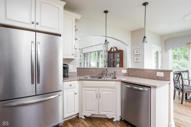 47 Torrey Pine Dr, Brownsburg, IN 46112 - kitchen featuring appliances with stainless steel finishes, healthy amount of natural light, wood finished floors, and a peninsula