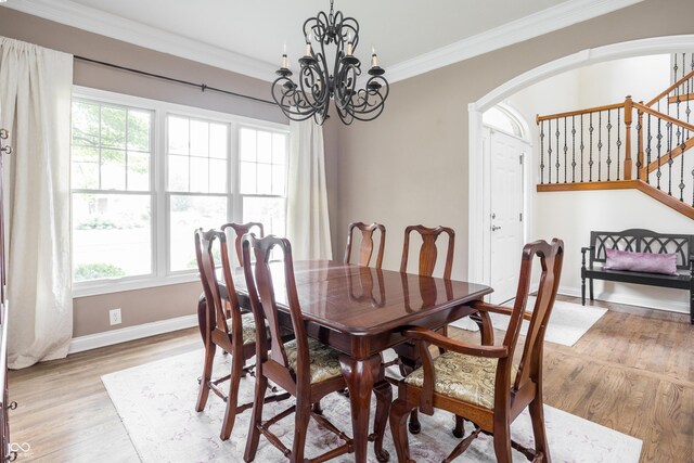 47 Torrey Pine Dr, Brownsburg, IN 46112 - dining space featuring arched walkways, stairway, light wood-type flooring, ornamental molding, and a chandelier