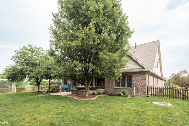 47 Torrey Pine Dr, Brownsburg, IN 46112 - back of house with brick siding, a fenced backyard, a fire pit, a patio, and roof with shingles