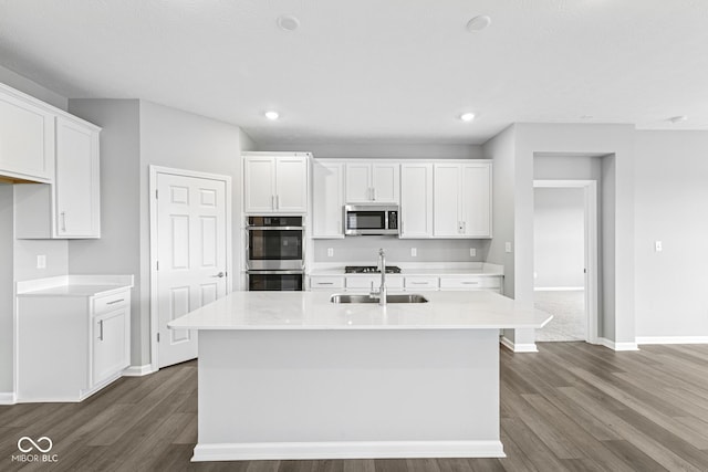 12516 Morning Ridge Way, Noblesville, IN 46060 - kitchen with dark wood-type flooring, appliances with stainless steel finishes, white cabinets, light countertops, and a center island with sink